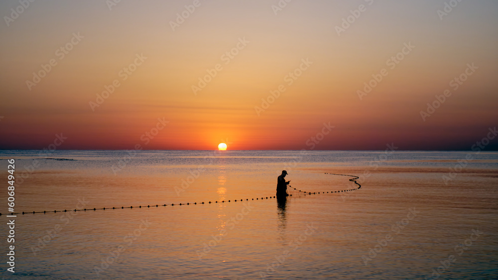 fisherman with net at dawn
