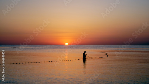 fisherman with net at dawn
