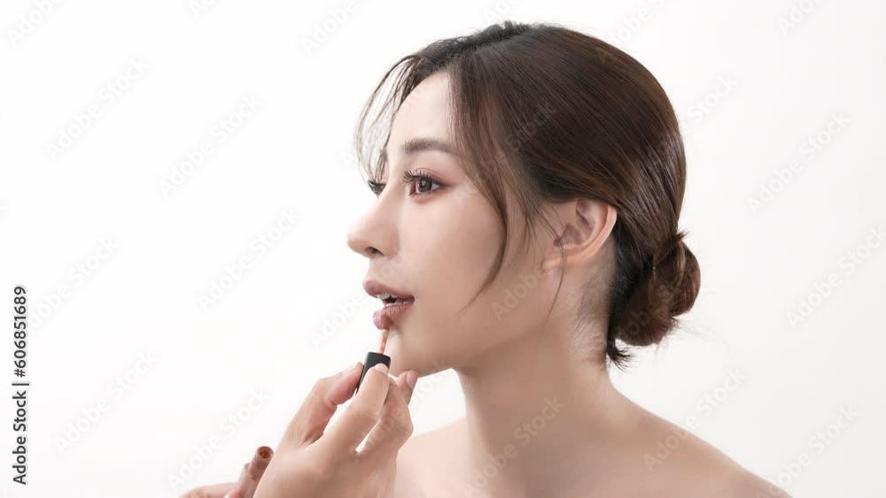 Beauty concept of 4k Resolution. Makeup artist applying lips to Asian woman on white background. Beauty concept of 4k Resolution. Makeup artist applying lips to Asian woman on white background.