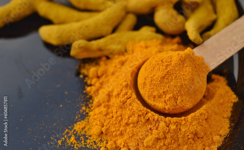 A closeup selective focus picture of Turmeric powder with termeric sticks