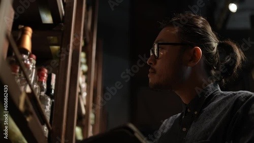 Night club concept of 4k Resolution. The bartender is checking the merchandise in the store. A group of specialized clubs that sell alcoholic beverages.