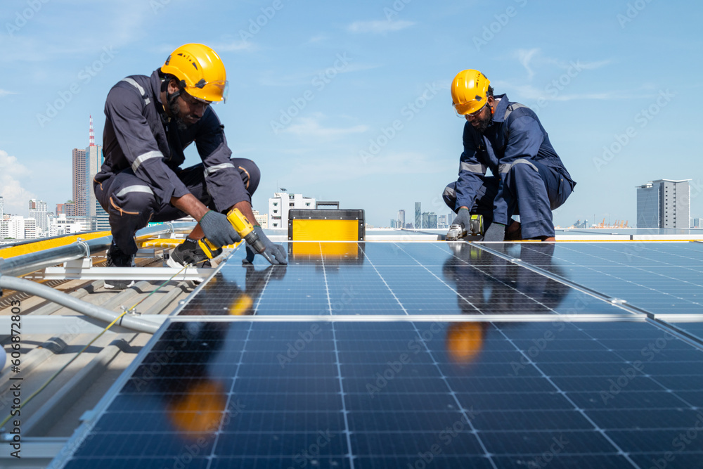 Engineers and technicians check drawings for installing solar cell panels on the roof. alternative energy energy from the sun Engineers and technicians check drawings for installing solar cell panels on the roof. alternative energy energy from the sun