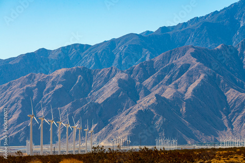 Wind turbines seen in Palm Springs with large mountains of San Jacinto in background. Taken in California desert with beautiful landscape, power technology in view. 