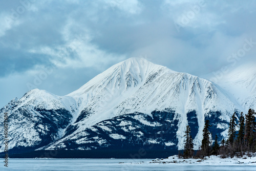 Foto Incredible snow capped mountains in the winter time with a frozen lake in foreground