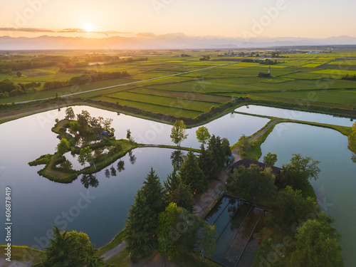 Aerial countryside landscape in Italy with fields and lake in foreground, Novara, Italy