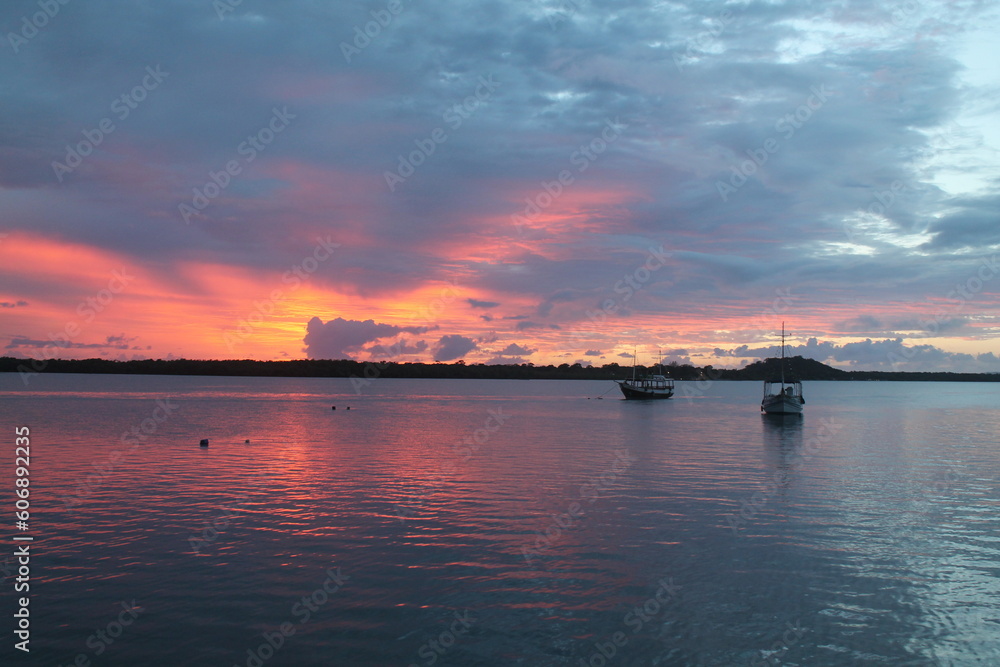 A tranquil sunset over calm waters with a boat near Ilha do Cardoso in Cananéia
