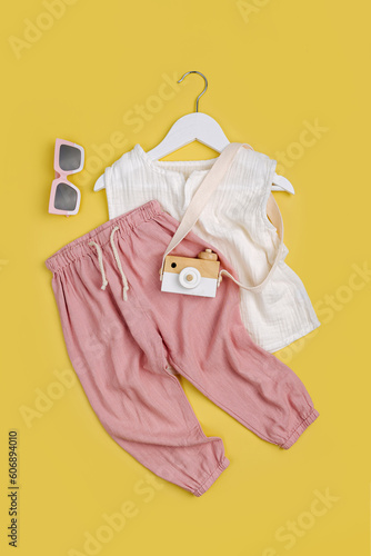 White Cotton T-shirt with pink trousers. Stylish baby clothes and accessories for summer. Fashion kids outfit. Flat lay, top view
