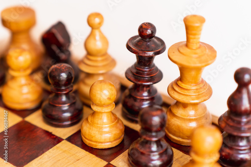 detail photograph of chess pieces of different colors on game board, theme of equality and peace