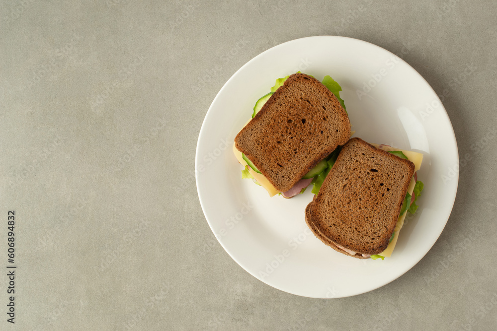 sandwich with meat, cheese and vegetables on a gray background sandwich with meat, cheese and vegetables on a gray background