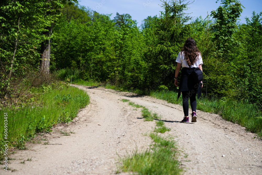Młoda dziewczyna idzie po leśnym szlaku