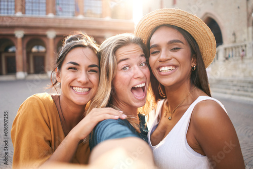 Three cheerful girls friends in summer clothes taking a selfie outdoors at the touristic urban center city. High quality photo