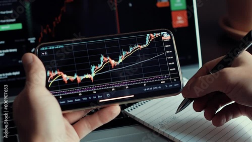 investment stockbroker stock market analysis data graph with price rates. Stock market trader analyzing bitcoin price trend. Investment broker trading bitcoin crypto currency using phone and laptop