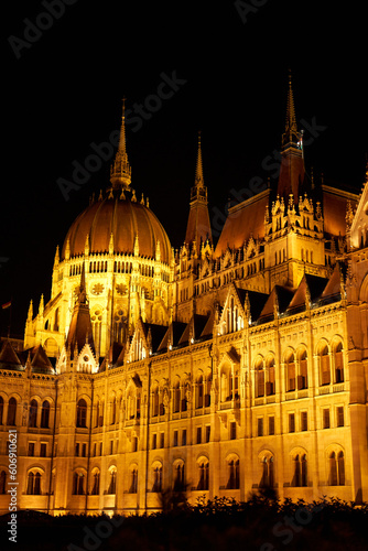 Evening photo of the Parliament building in Budapest.The majestic Saxon architecture is illuminated with warm yellow light