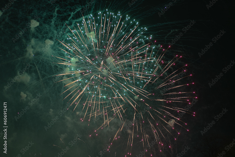 Green and yellow fireworks celebration in the sky. Very cheap firework over the city, green, yellow