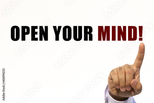 Open your mind text on white wall background with businessman's finger point at the message with empty space. This message can be used as business concept about opening your mind.