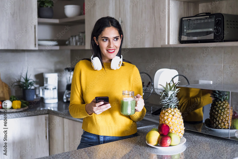Φωτογραφία Latin adult woman drinking detox drink or green juice in kitchen at home in Mexi
