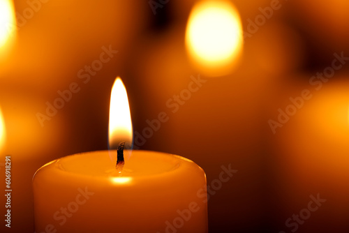 Burning candle on blurred background, closeup. Space for text