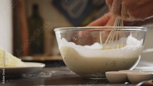 Home cooking - a man making batter mix for quiche Lorraine. Low angle closeup shot.