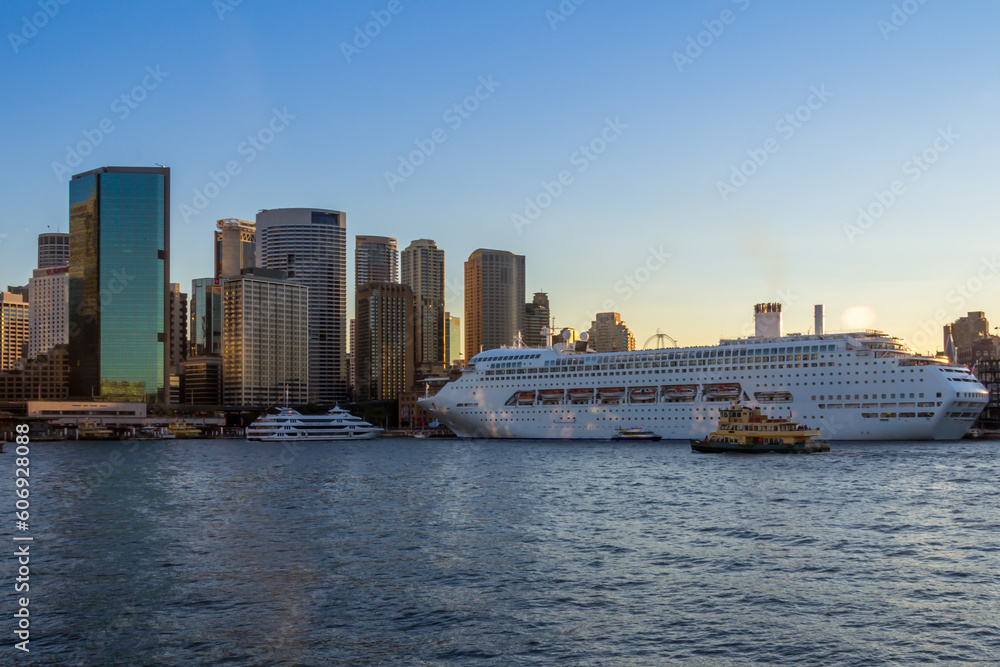 Cruise ship docked at Circular Quay and Sydney skyline at sunset