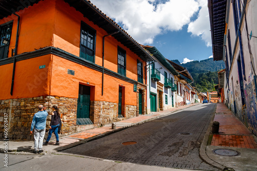 Fototapeta Naklejka Na Ścianę i Meble -  Two tourists walk the streets of the La Candelaria district in Bogota, Colombia