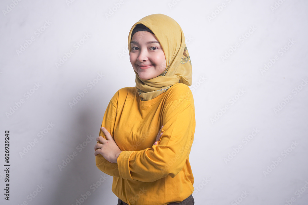 Cheerful Asian muslim woman in orange t-shirt crossing hands and smiling at camera Cheerful Asian muslim woman in orange t-shirt crossing hands and smiling at camera