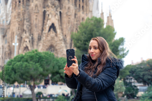 Photography Serious young Latin woman traveler in warm outfit with photo camera rest on a pa