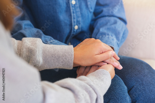 Closeup image of a couple women holding each other hands for comfort and sympathy