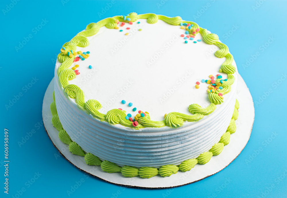 Φωτογραφία Circular White Ice Cream Cake with Colorful Border and Sprinkles on a Blue Backg