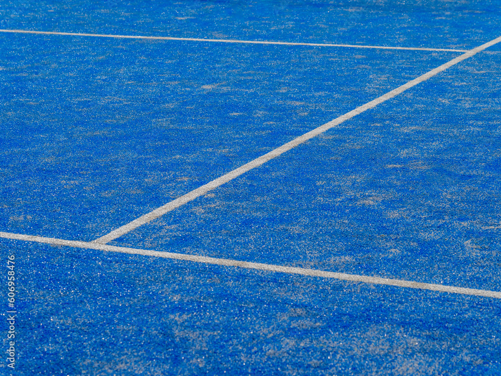 Detail of a new synthetic tennis court. White lines on a blue artificial grass tennis court. Racket sports concept