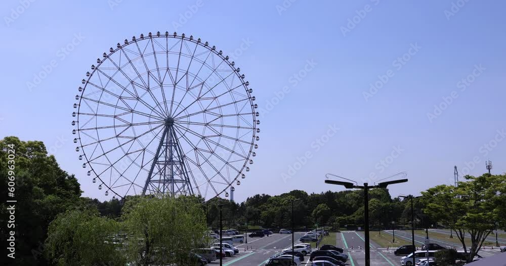 A moving ferris wheel at the park behind the blue sky A moving ferris wheel at the park behind the blue sky