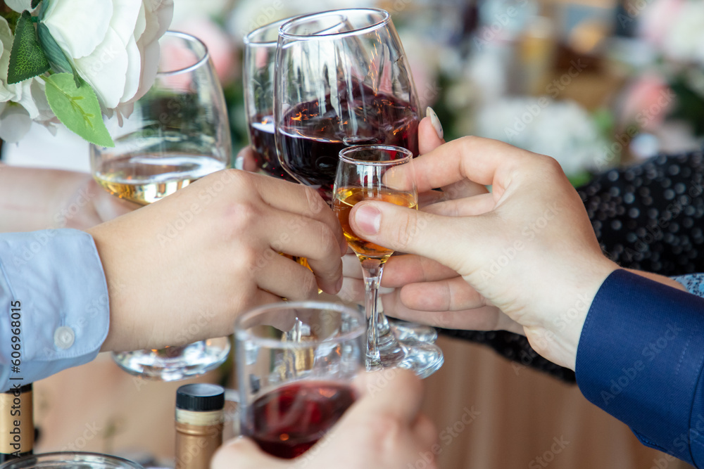 Hands of people clinking glasses with red and white wine in restaurant Hands of people clinking glasses with red and white wine in restaurant