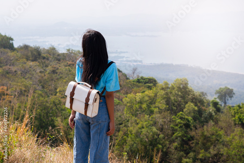 young girl with backpack, hat and looking at amazing mountains and Wind Turbine on the mountain,space for text, Khao Yai Thieng Thailand. photo