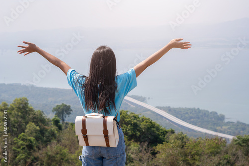 young girl with backpack, hat and looking at amazing mountains and Wind Turbine on the mountain,space for text, Khao Yai Thieng Thailand. photo