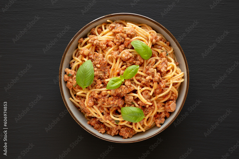 Homemade Tomato Basil Sausage Spaghetti in a Bowl on a black background, top view. Flat lay, overhead, from above.