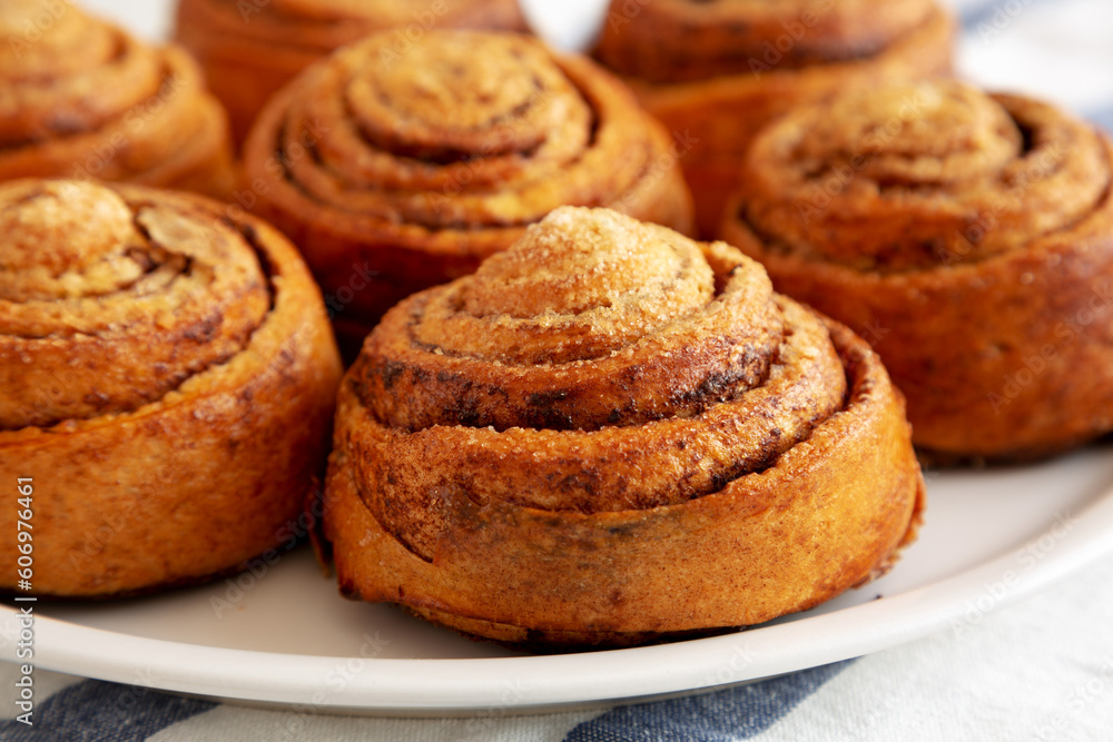 Homemade Cinnamon Roll Pastry on a white wooden background, low angle view. Close-up. Homemade Cinnamon Roll Pastry on a white wooden background, low angle view. Close-up.