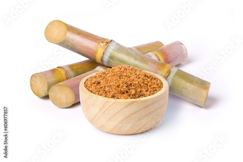 Brown unrefined cane sugar in wooden bowl with fresh sugar cane isolated on white background, 