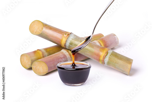 Sugarcane syrup molasses with fresh sugar cane isolated on white photo