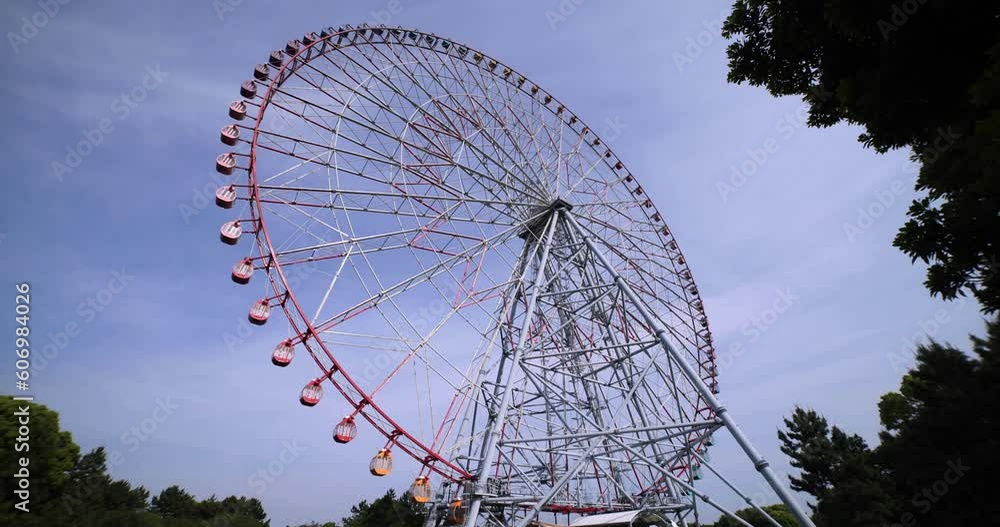A moving ferris wheel at the park behind the blue sky wide shot A moving ferris wheel at the park behind the blue sky wide shot