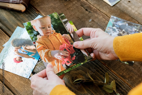 Young woman looking at printed photos for family picture album.