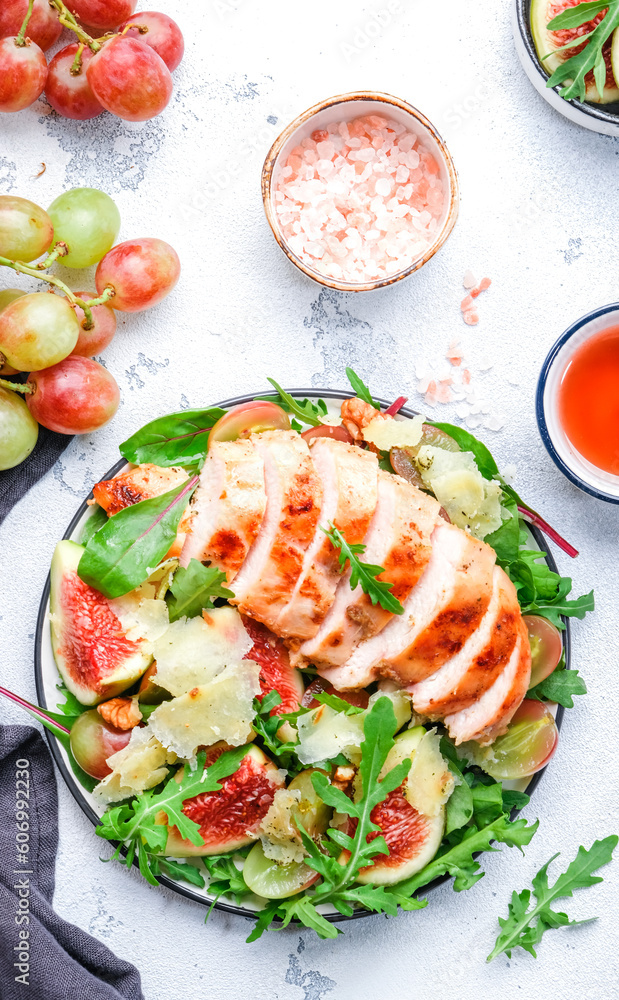 Gourmet salad with fresh figs and grilled chicken fillet, grape, arugula, chard with wine vinegar dressing. White kitchen table background, top view Gourmet salad with fresh figs and grilled chicken fillet, grape, arugula, chard with wine vinegar dressing. White kitchen table background, top view