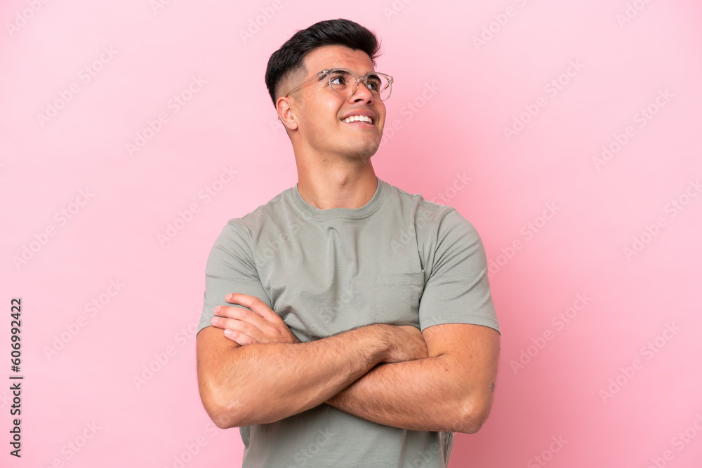 Young caucasian handsome man isolated on pink background looking up while smiling Young caucasian handsome man isolated on pink background looking up while smiling