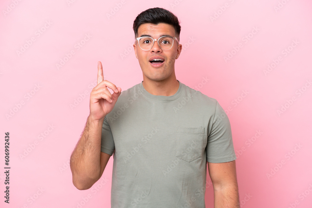 Young caucasian handsome man isolated on pink background thinking an idea pointing the finger up Young caucasian handsome man isolated on pink background thinking an idea pointing the finger up