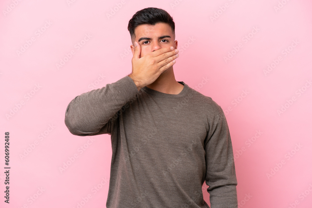 Young caucasian handsome man isolated on pink background covering mouth with hand Young caucasian handsome man isolated on pink background covering mouth with hand
