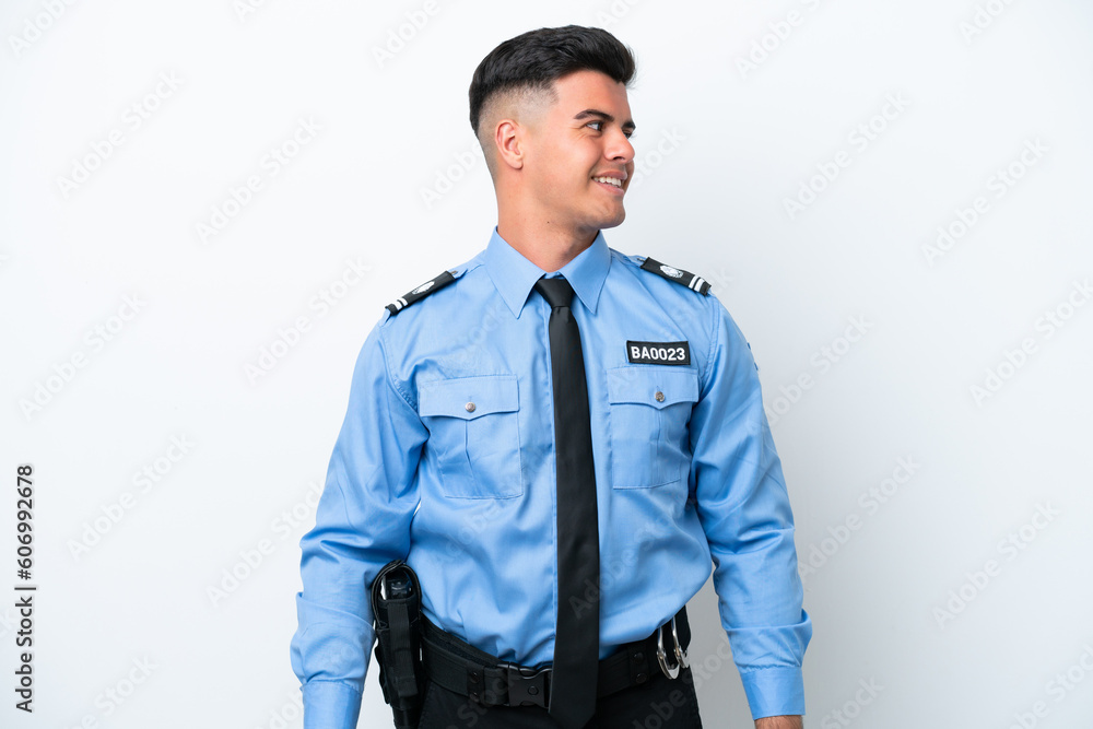 Fototapeta premium Young police caucasian man isolated on white background looking side