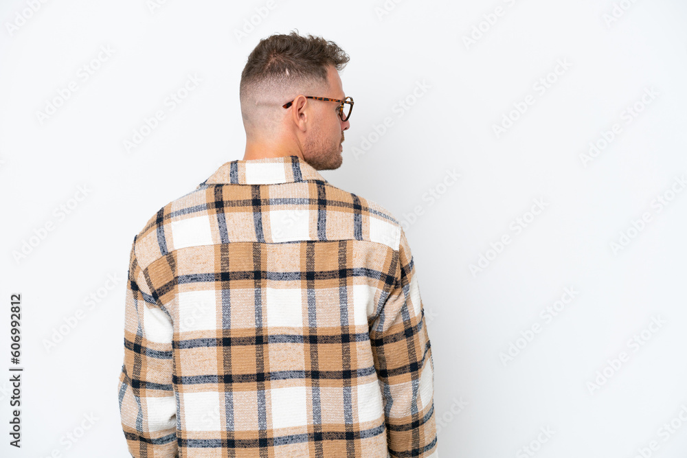Young caucasian handsome man isolated on white background in back position and looking side Young caucasian handsome man isolated on white background in back position and looking side