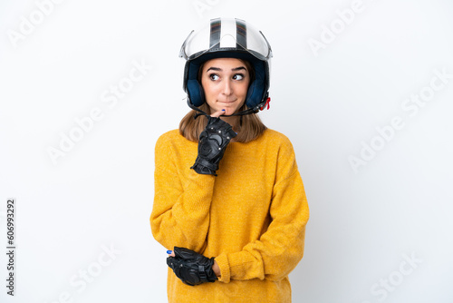 Young caucasian woman with a motorcycle helmet isolated on white background having doubts and thinking