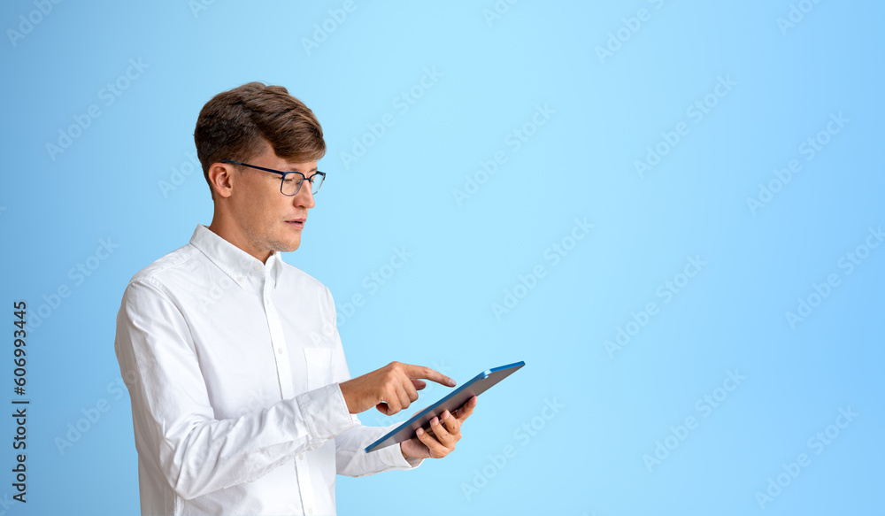 Businessman with tablet in hand, portrait on copy space blue background Businessman with tablet in hand, portrait on copy space blue background