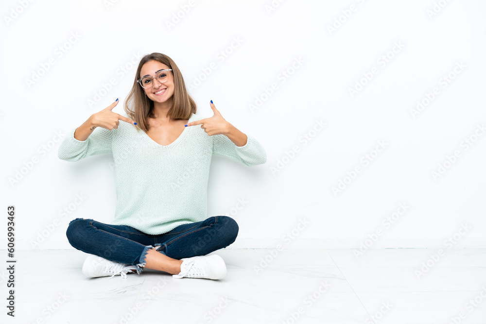 Young caucasian woman sitting on the floor isolated on white background proud and self-satisfied Young caucasian woman sitting on the floor isolated on white background proud and self-satisfied