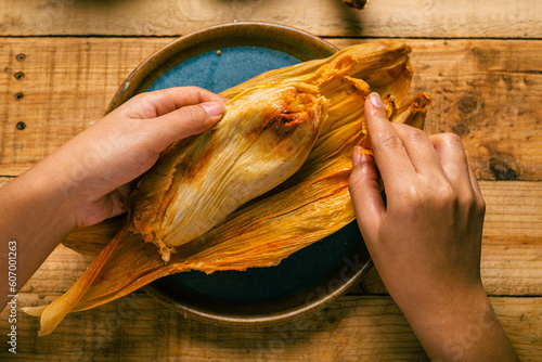 Cuadro en lienzo Person opening a tamale with his hands