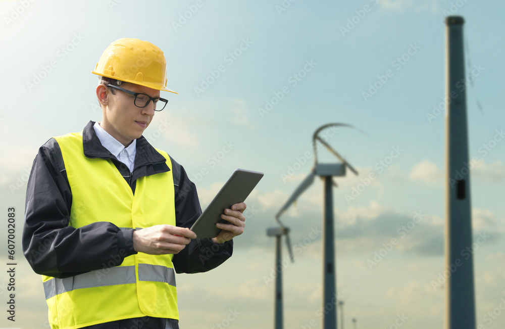 Engineer with tablet computer on a background of broken wind turbines	